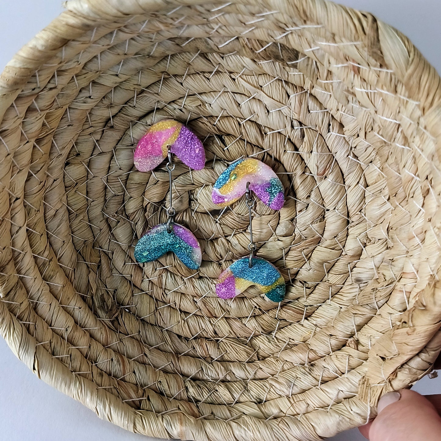 Colorful glittery earrings on a woven basket
