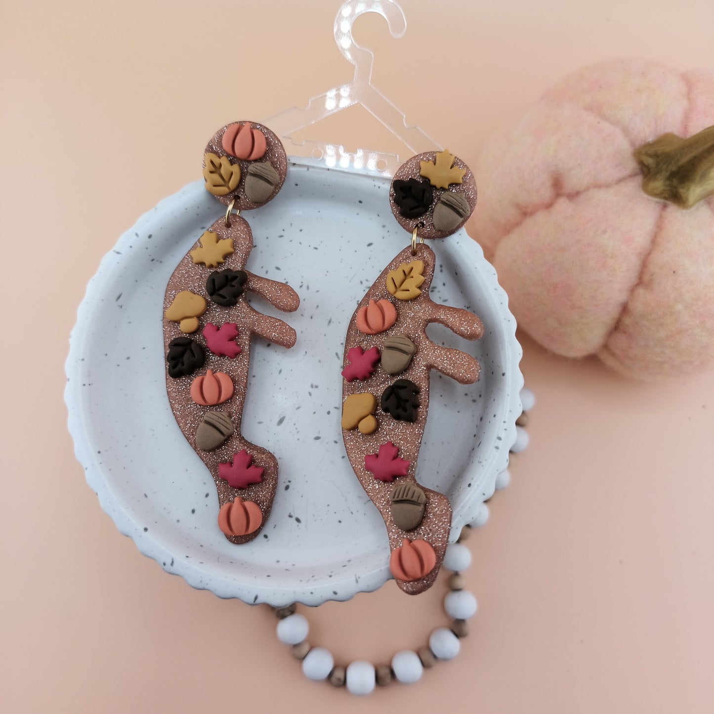Decorative autumn earrings with colorful fall designs on a white background