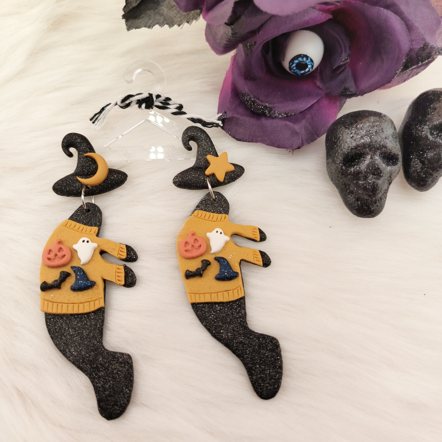 Halloween-themed manatee earrings with a witch design on a white background