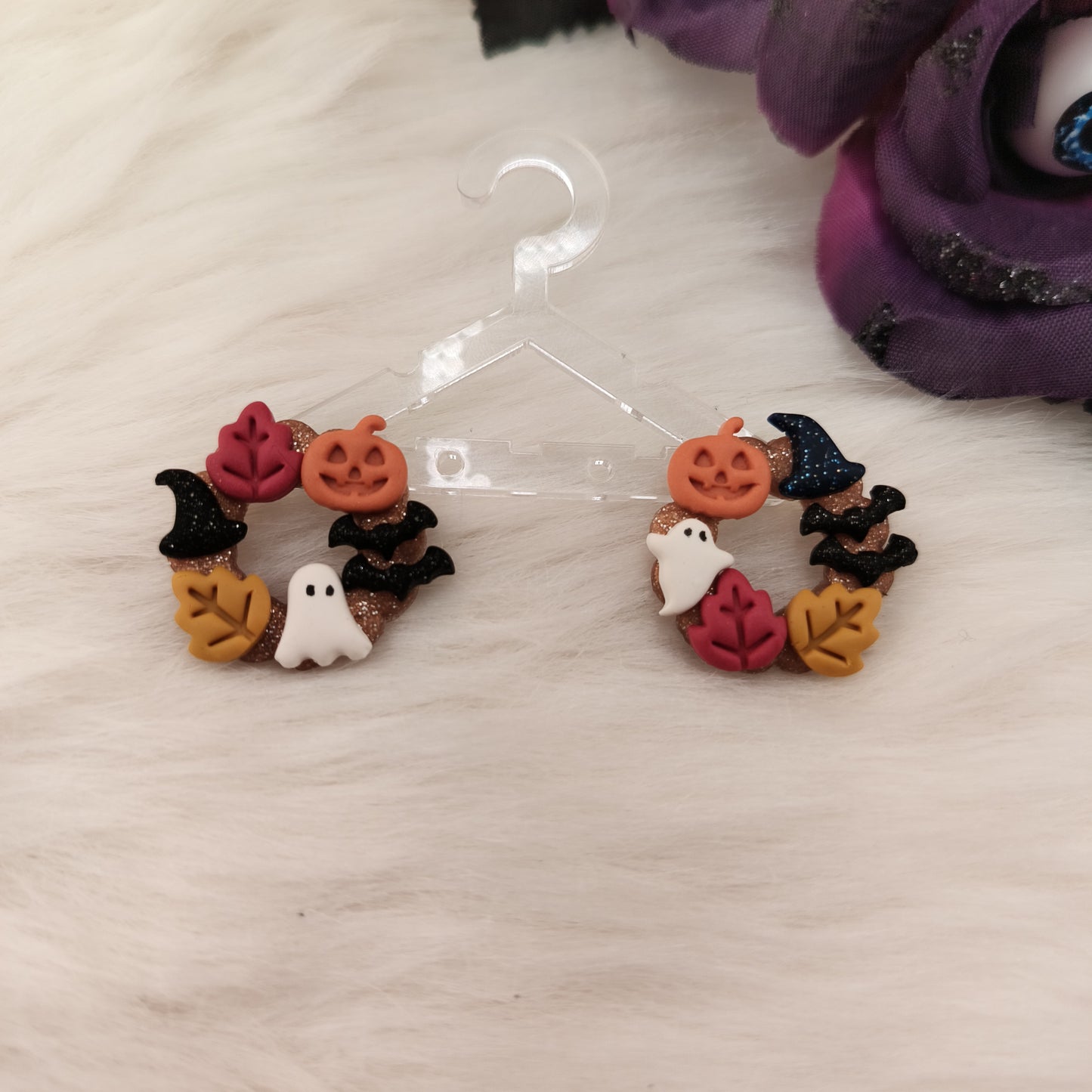 Halloween-themed earrings on a clear hanger with a neutral background