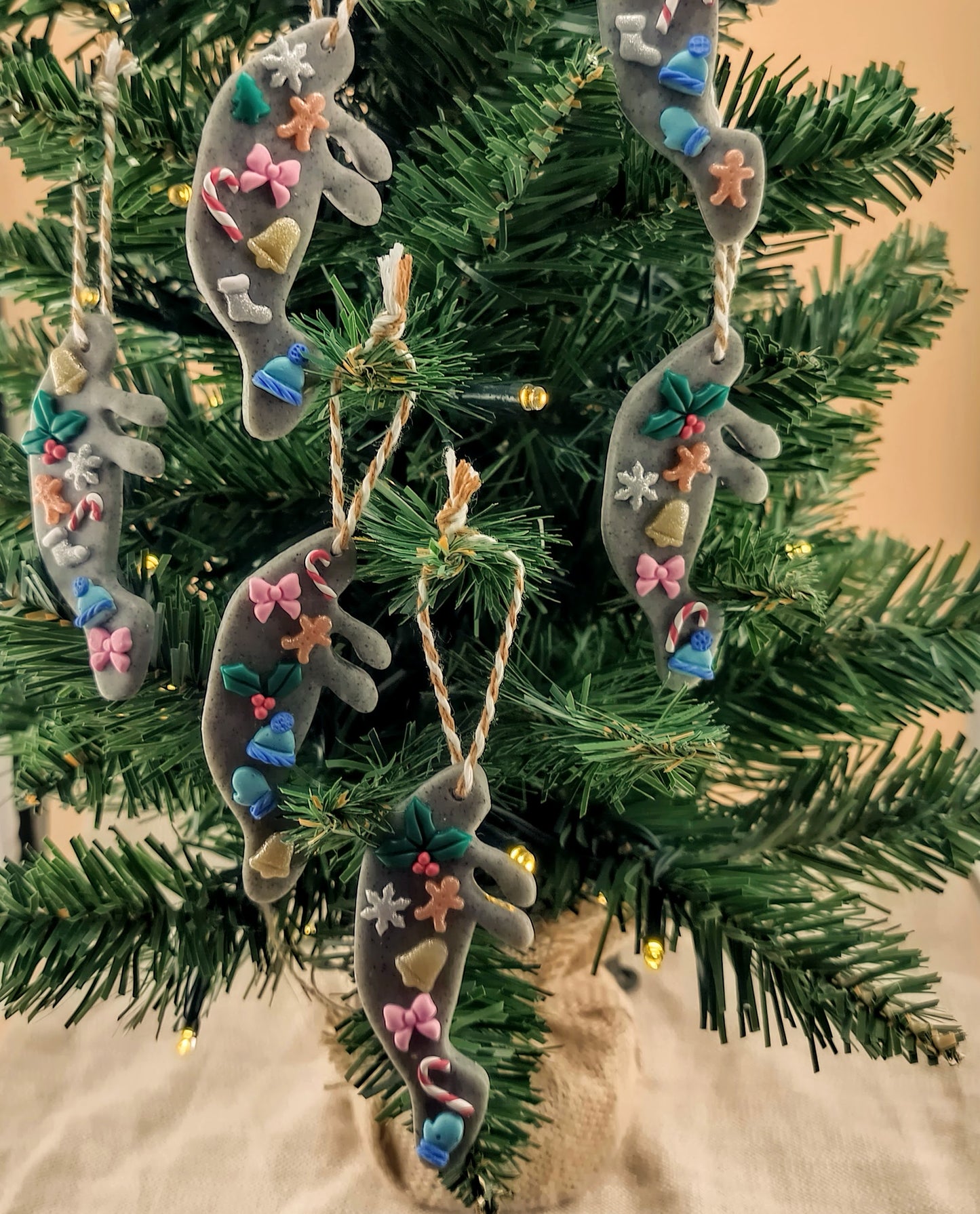 Decorative manatee Christmas ornaments on a tree with a neutral background