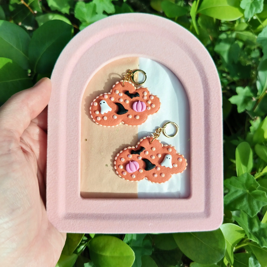 cloud earrings with a Halloween theme. tiny ghosts, witch hats, pumpkins, and bats.