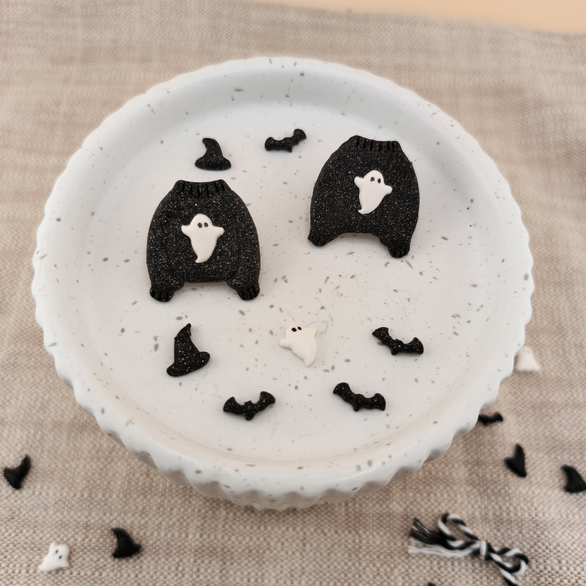 Halloween-themed dessert with ghost and bat decorations on a textured surface.