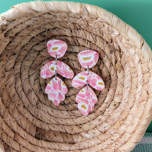 pink sparkle polymer clay earrings in natural basket against mint backdrop