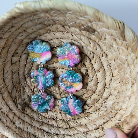 Colorful, sparkle flower-shaped earrings on a woven basket