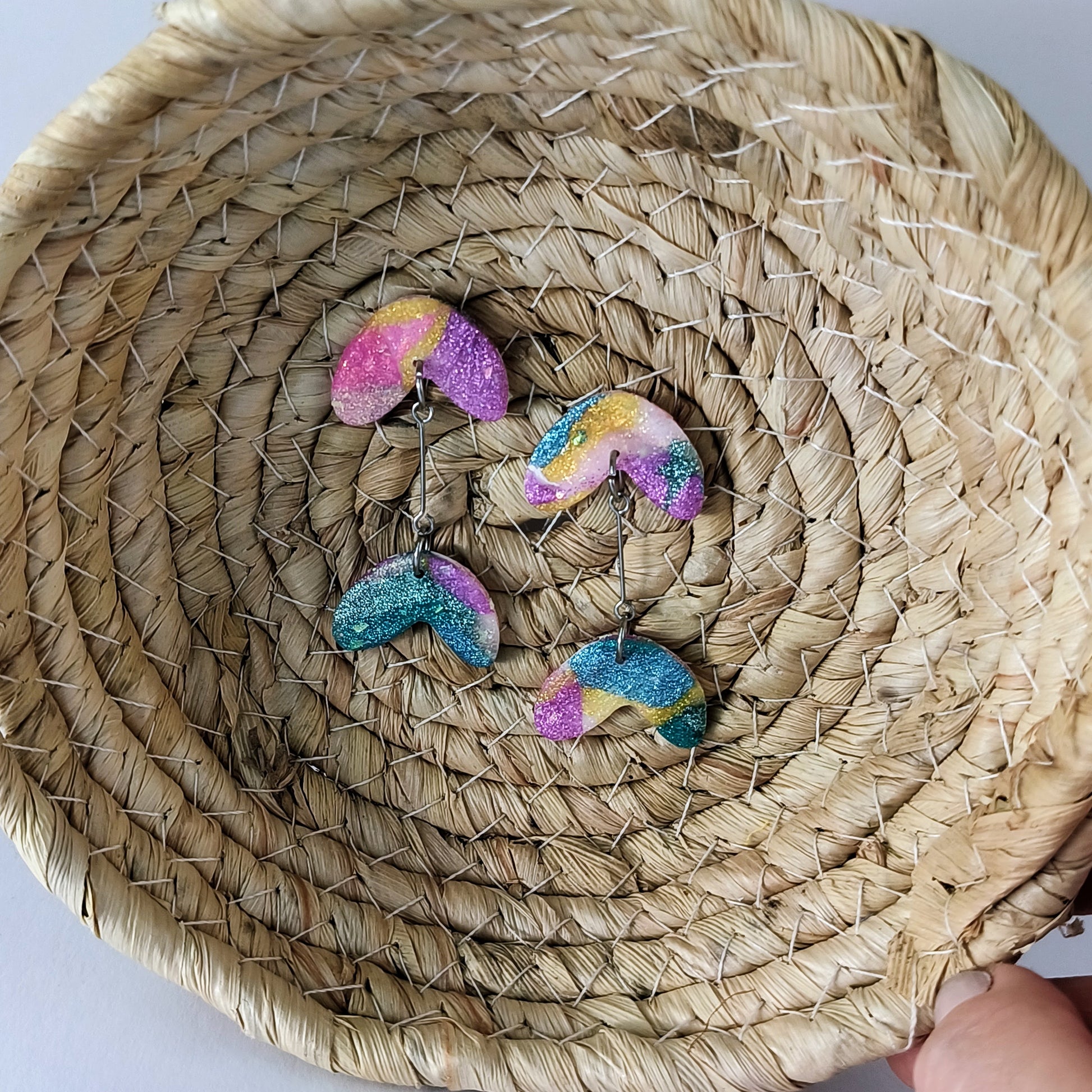 Colorful glittery earrings on a woven basket