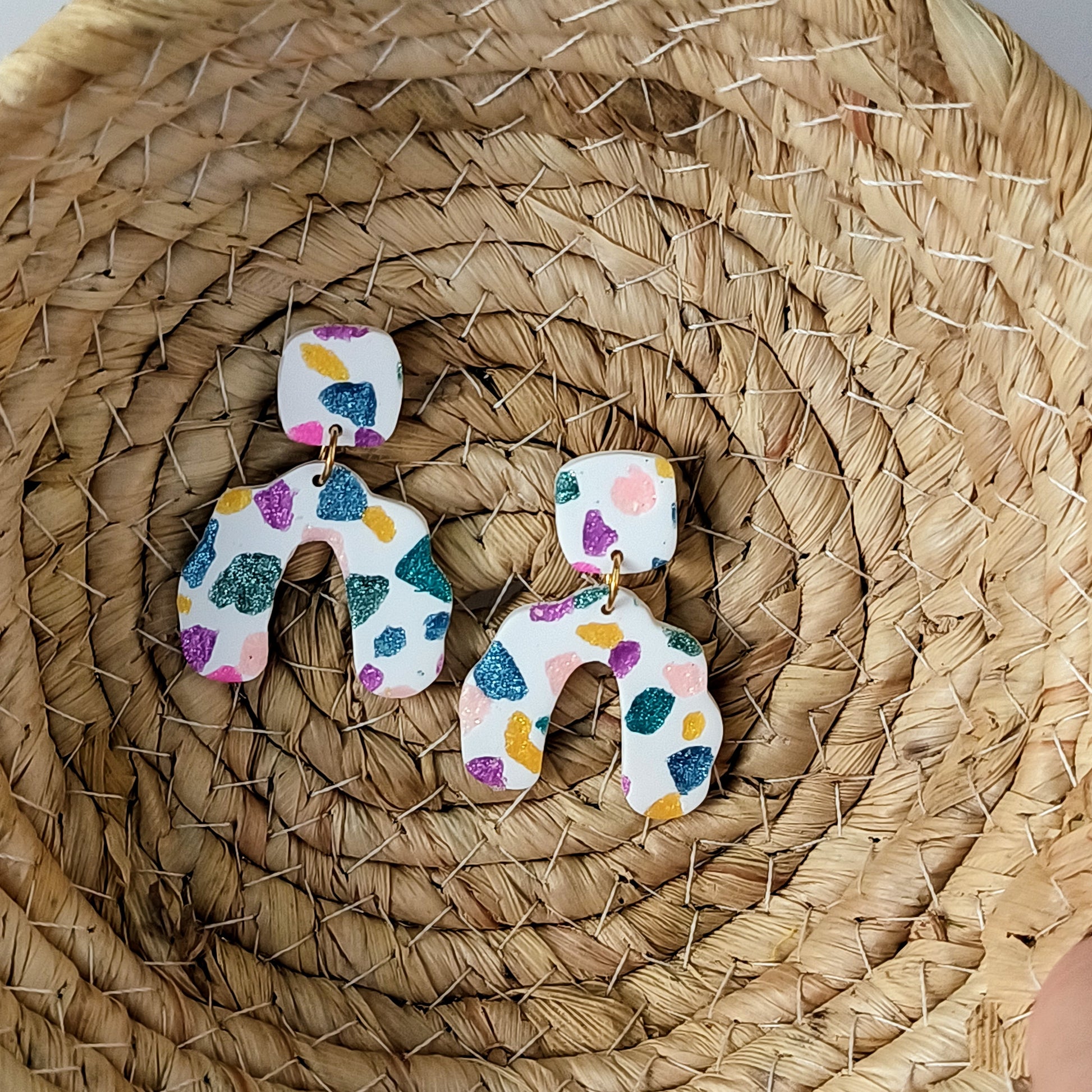 Colorful sparkle earrings on a woven basket
