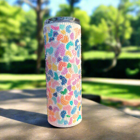 Rainbow terrazzo bedazzled tumbler with a natural background
