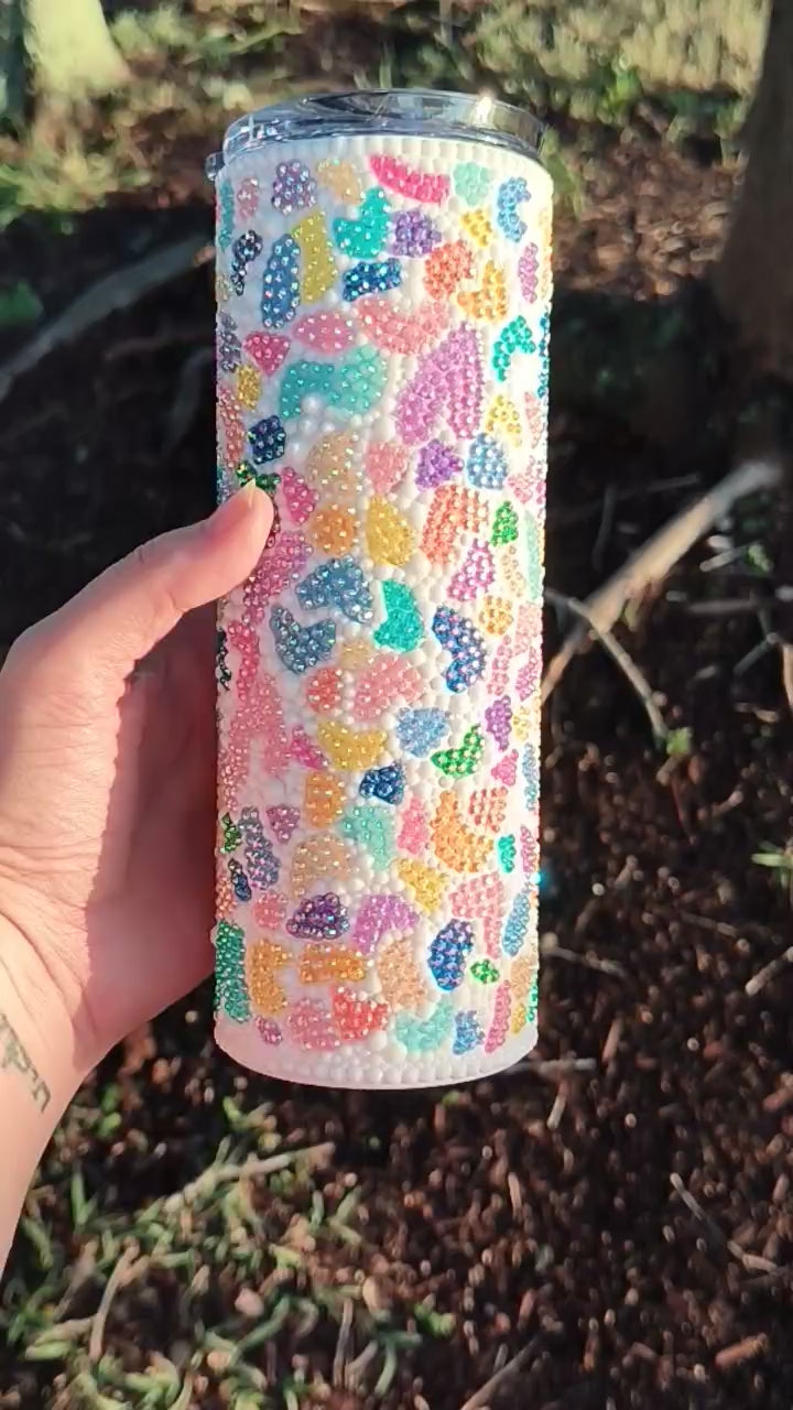 video featuring a multi colored terrazzo bedazzled tumbler, turning in a hand
