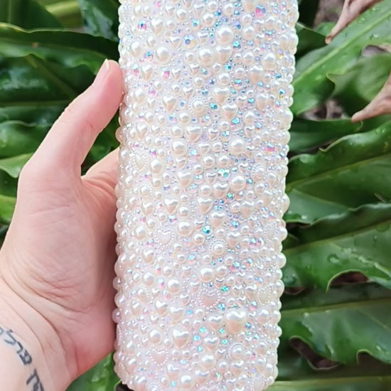 a video of the small details of this stainless-steel tumbler that is bedazzled with pearls, sparkly rhinestones, and pearl hearts of all sizes. Tumbler has a slide lid and metal straw. 