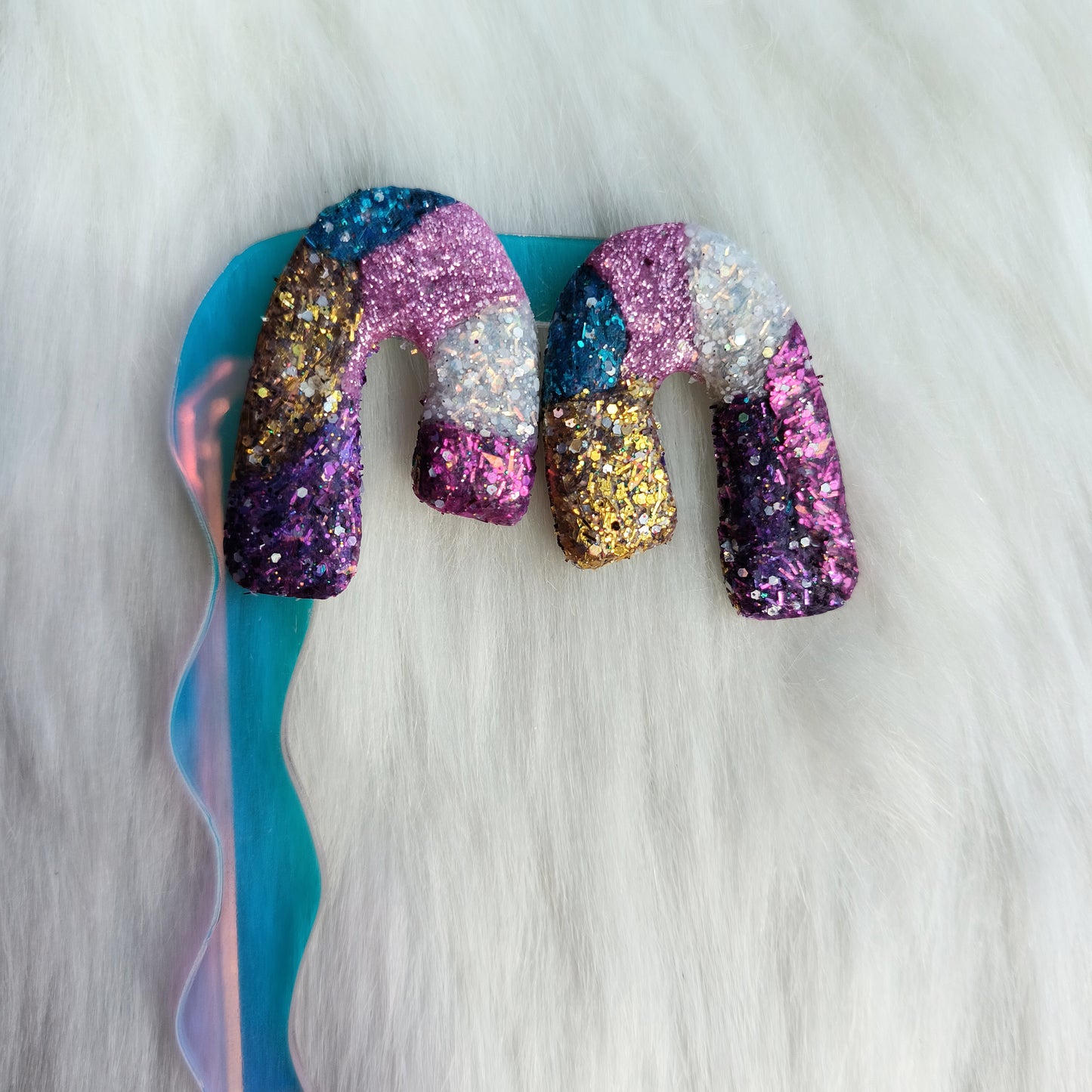 Multicolored glittery clay earrings on a white background