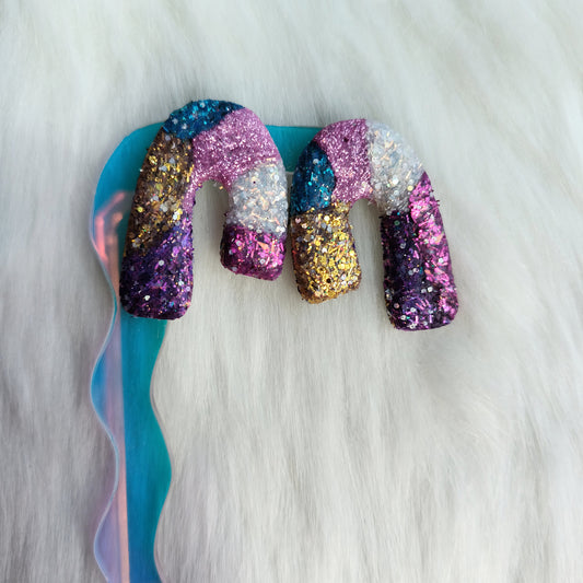 Multicolored glittery clay earrings on a white background
